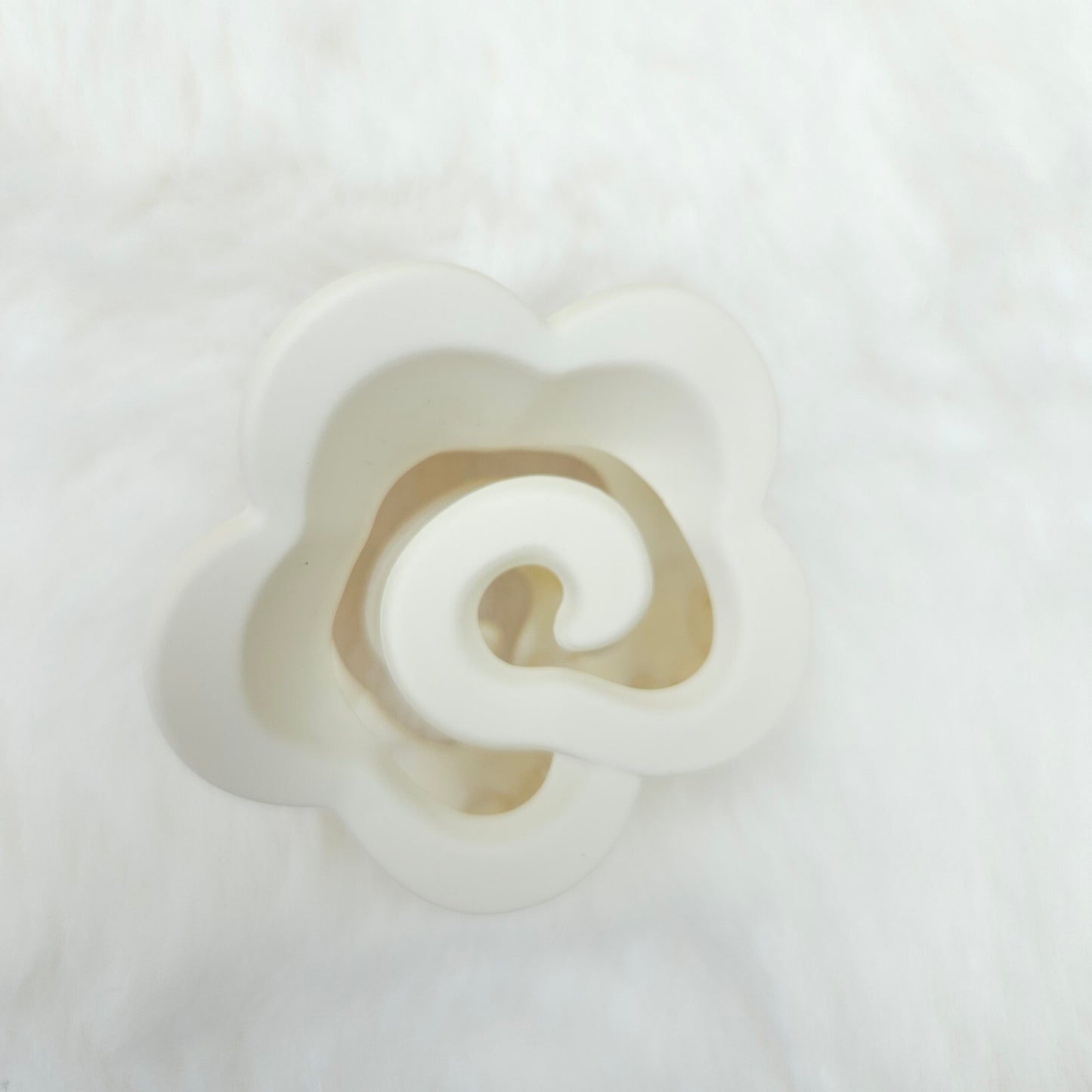 White spiral shaped hair claw on a white background