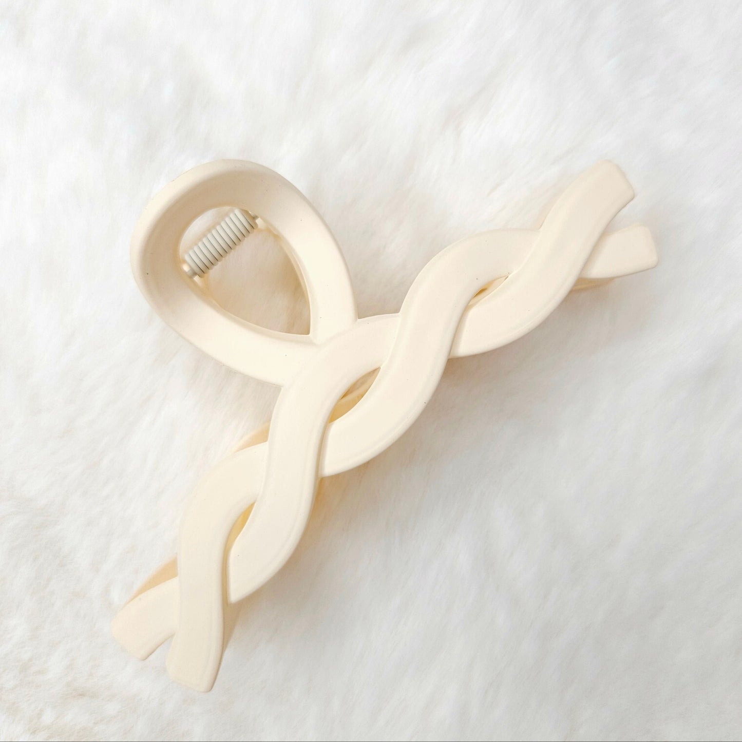 Off white twisted design hair claw clip on a white background