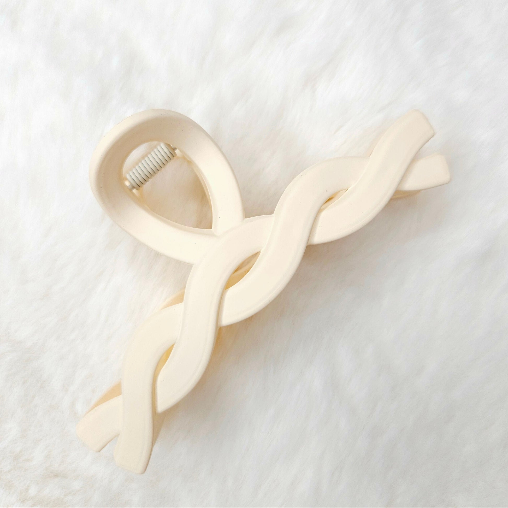 Off white twisted design hair claw clip on a white background