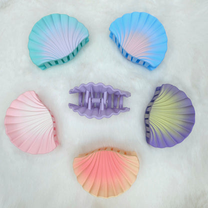 Set of colorful shell-shaped hair clips on a white background