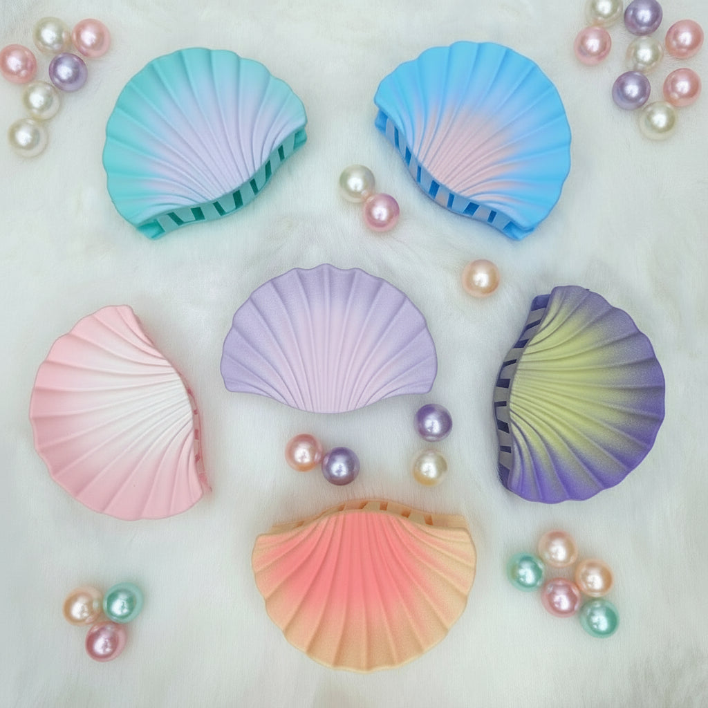 Set of colorful shell-shaped hair claws on a white background