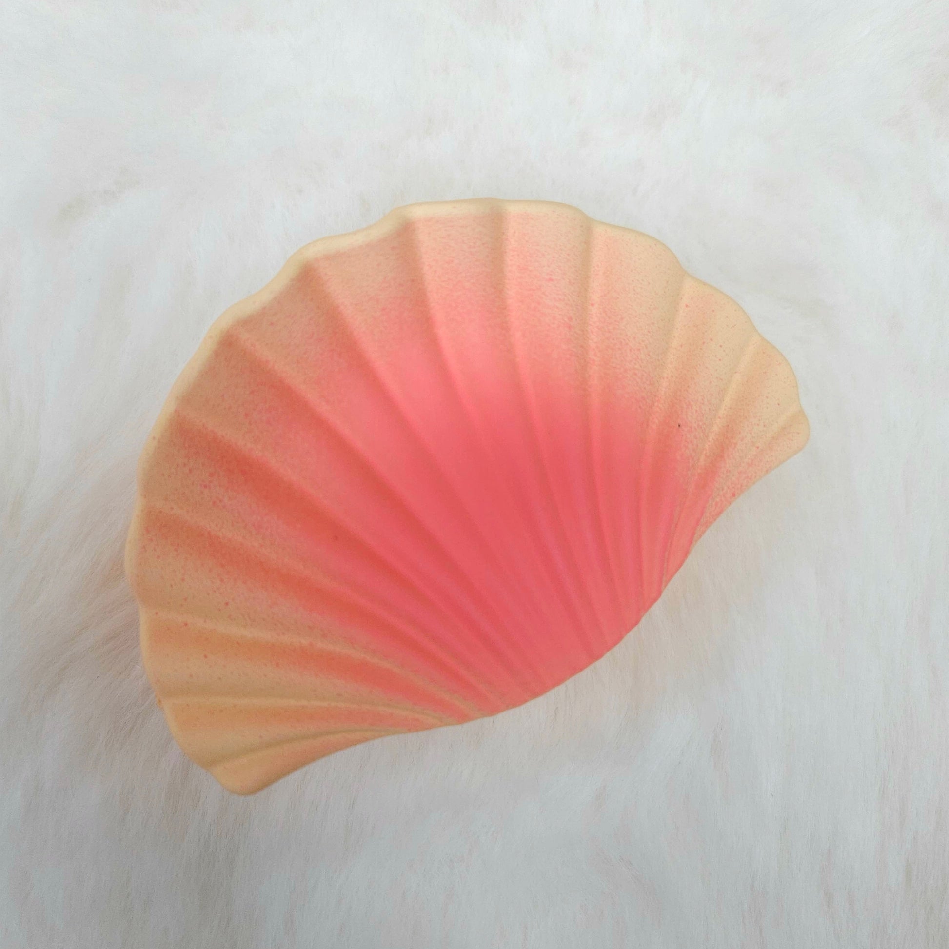 Orange shell-shaped hair claw on a white background