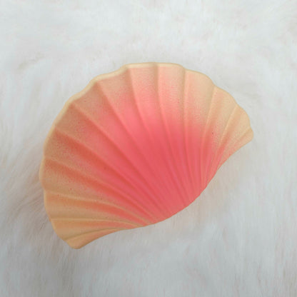 Orange shell-shaped hair claw on a white background