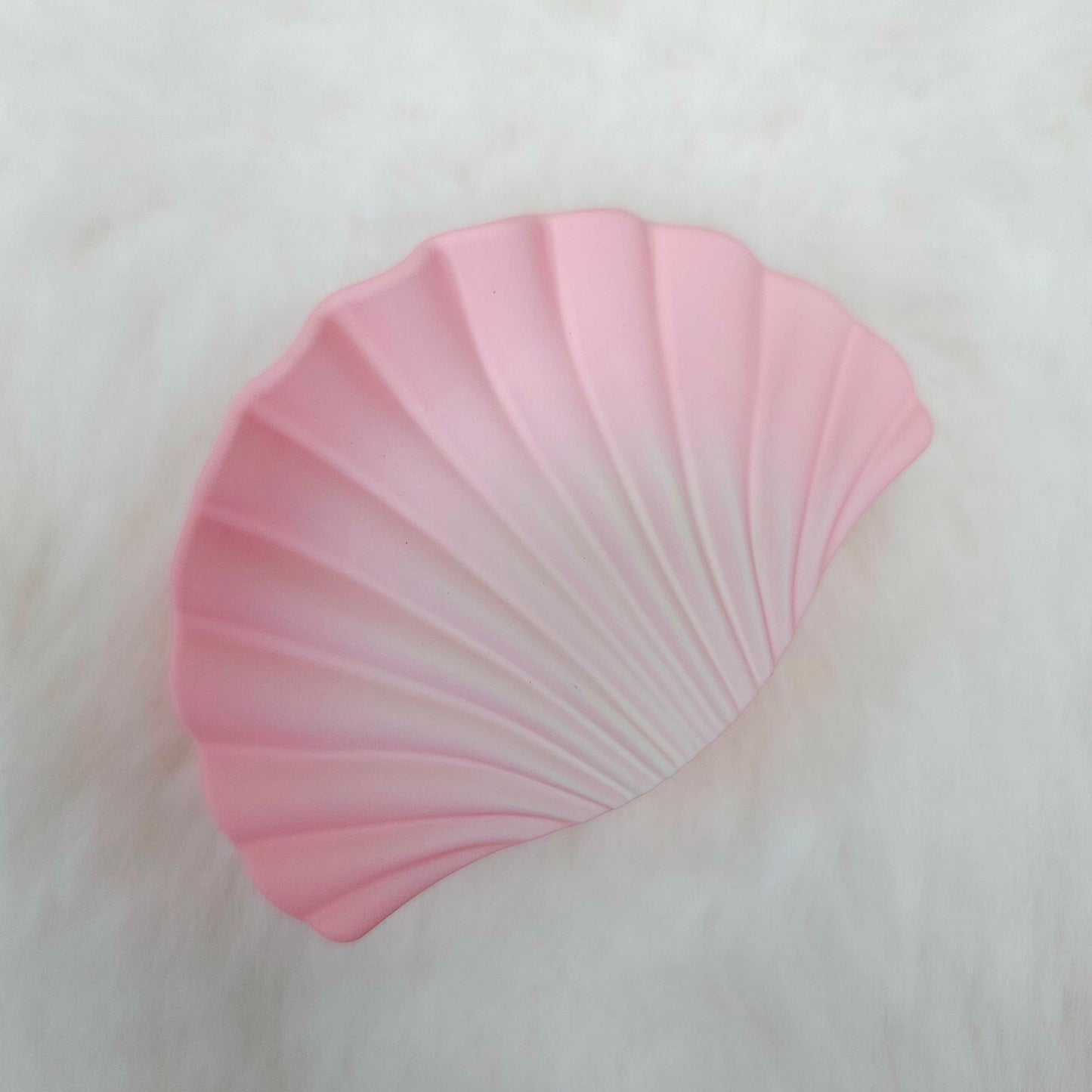 Pink shell shaped hair claw on a white background