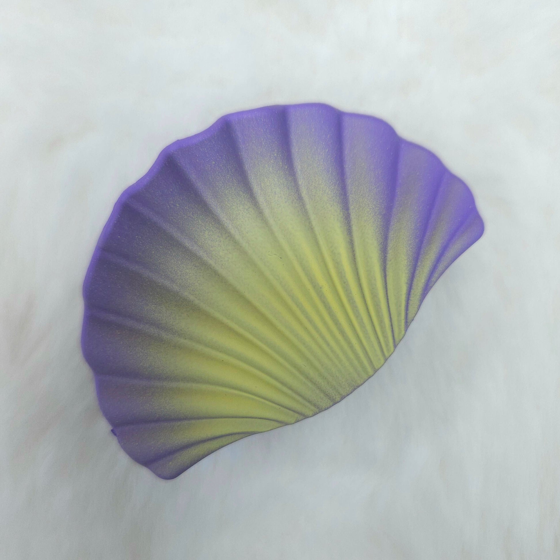 Gradient purple to green petal shell shaped hair claw on a white background