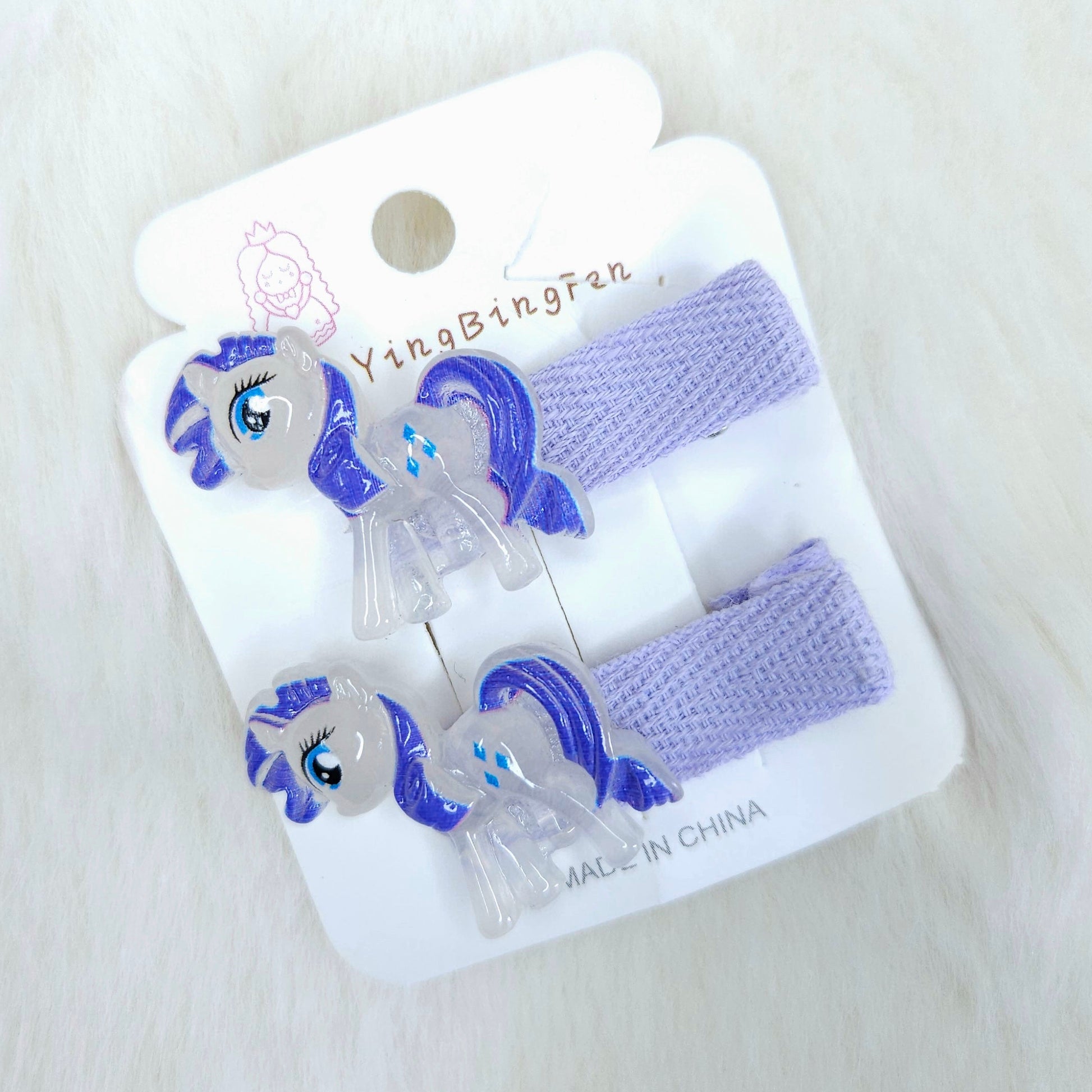 Packaged hair accessories with pony design on a white background