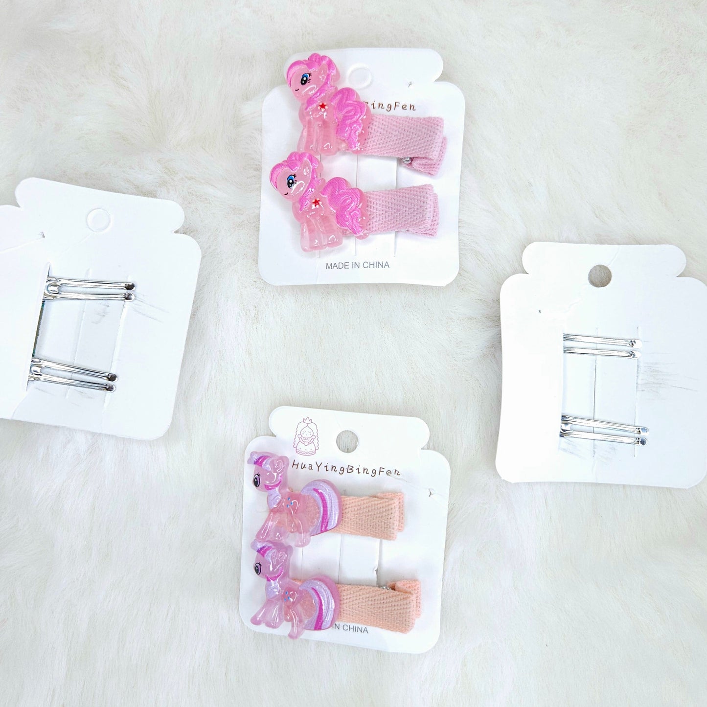 Set of pink hair clips on white cards against a light background