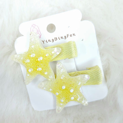 Star-shaped hair clips on a white card with 'YingBingFen' branding, placed on a white fluffy surface.
