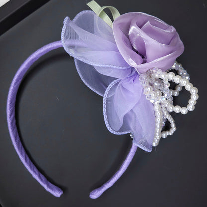 Purple floral headband with pearls on a black surface