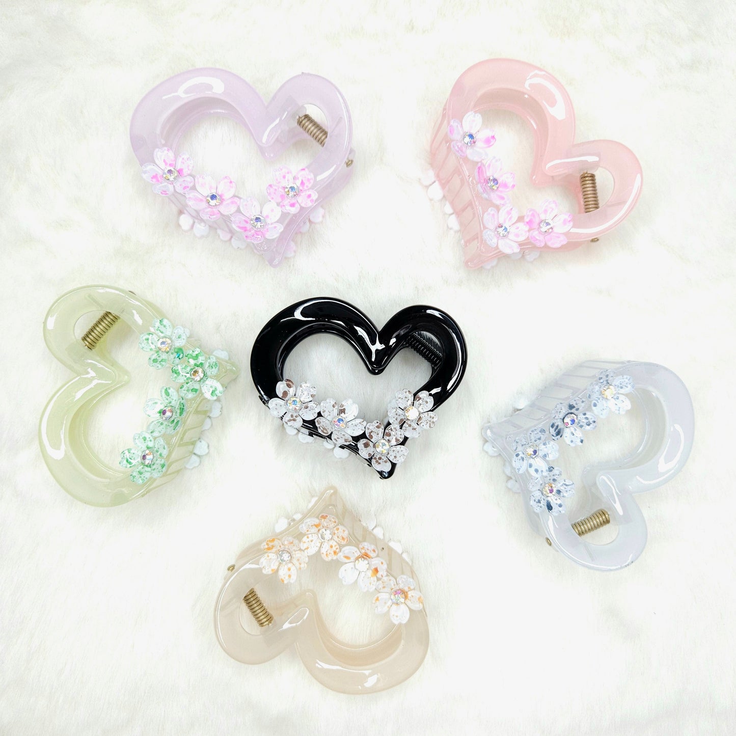 Heart-shaped hair clips in various colors on a light background