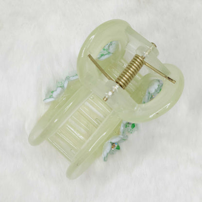 Vintage-style hair claw with a green glass shade on a white background