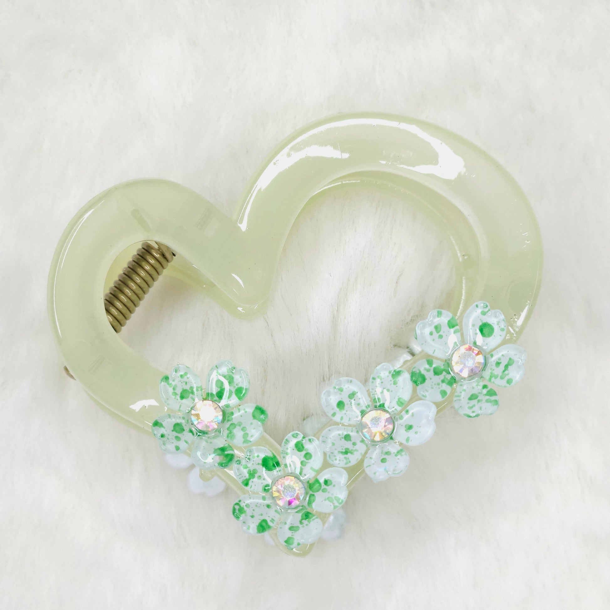 Heart-shaped hair clip with floral decorations on a white background