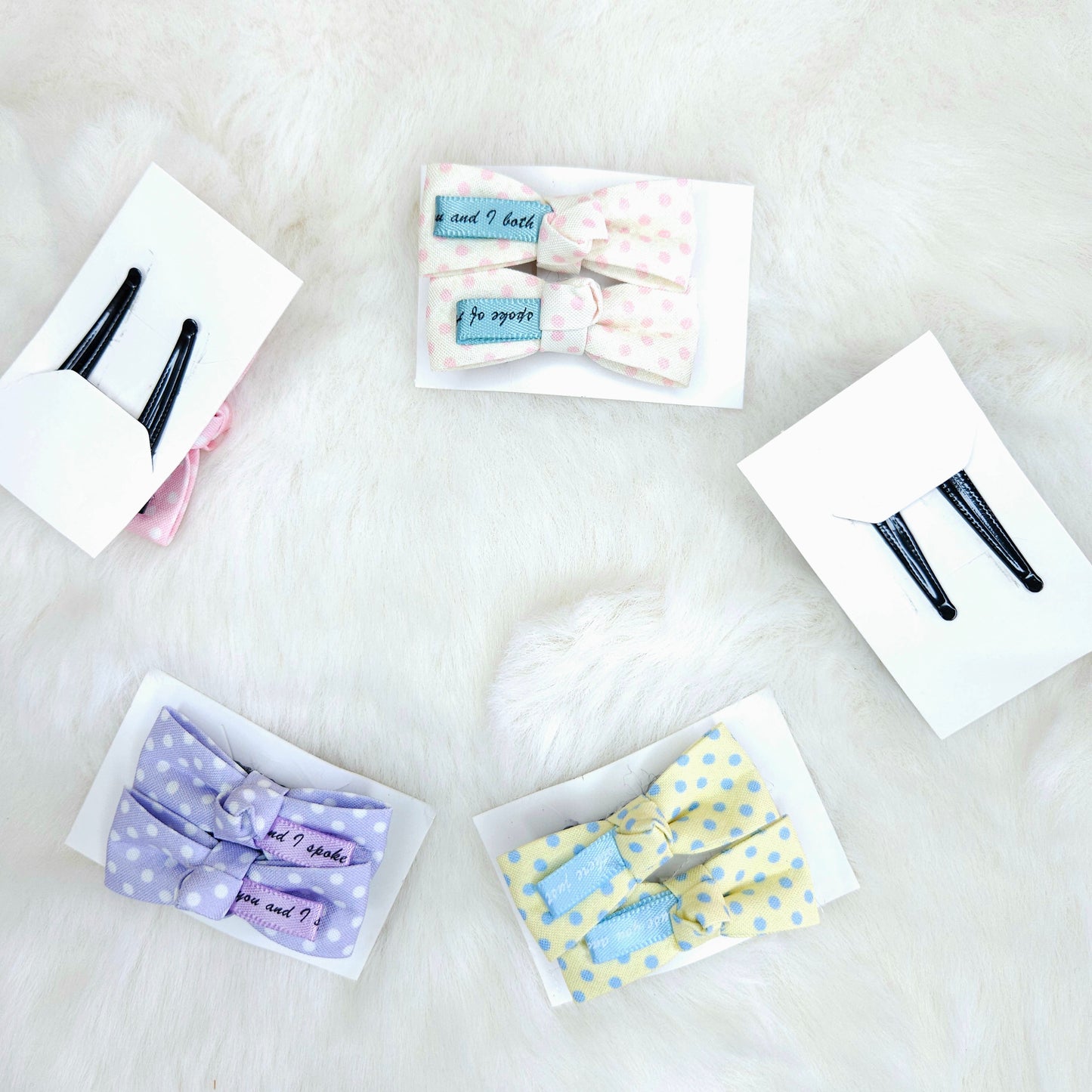 Collection of hair accessories including bows and clips on a white surface
