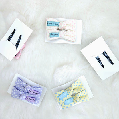 Collection of hair accessories including bows and clips on a white surface