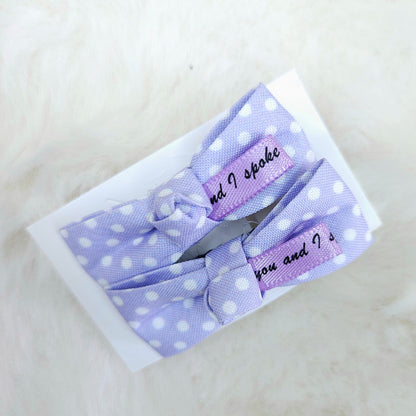 Set of purple polka dot hair clips on a white background