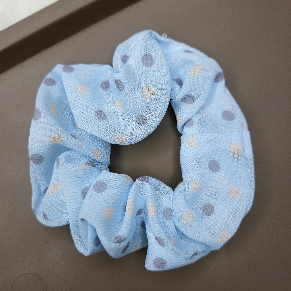 Blue scrunchie with polka dots on a brown surface