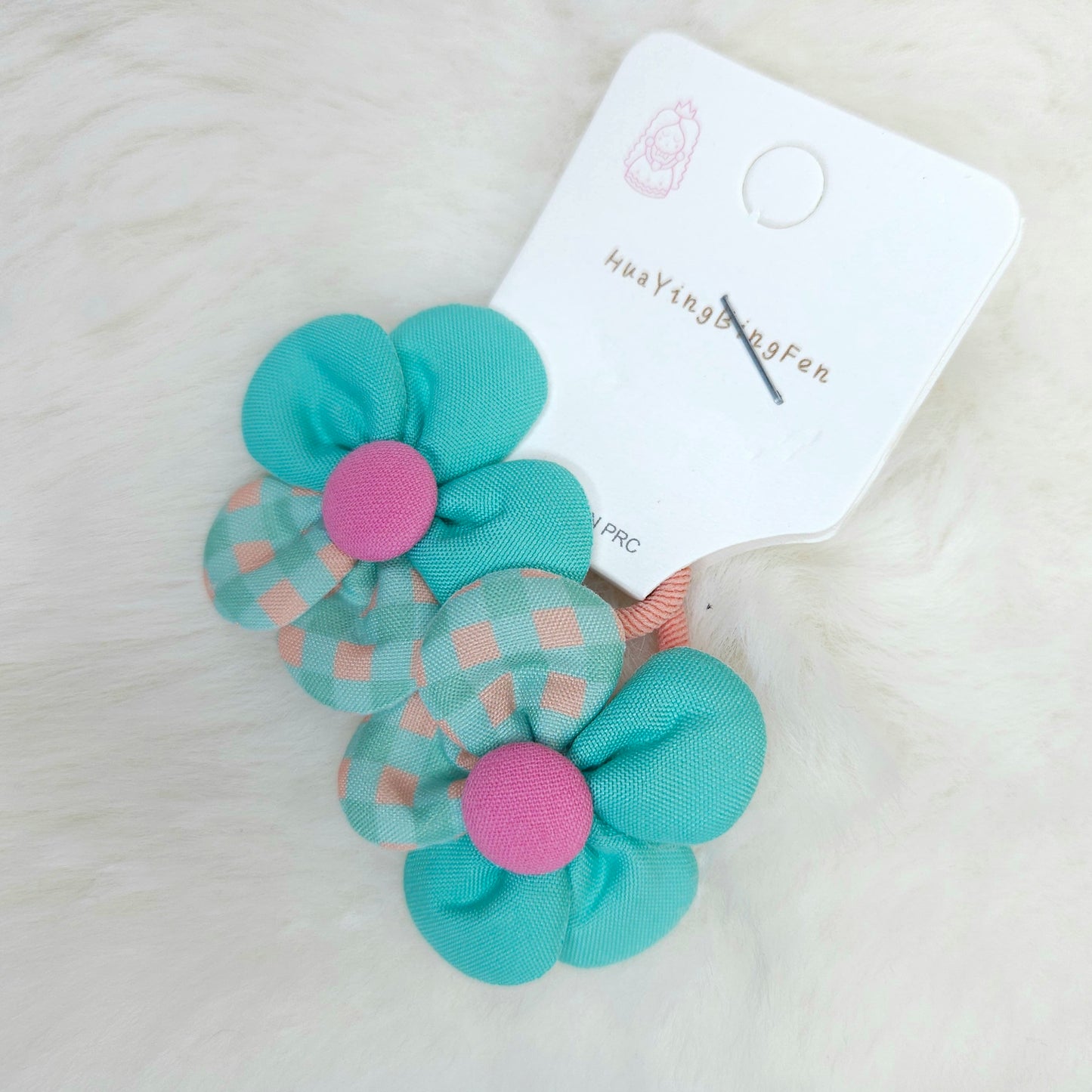 Turquoise flower-shaped hair clips with pink centers on a white background