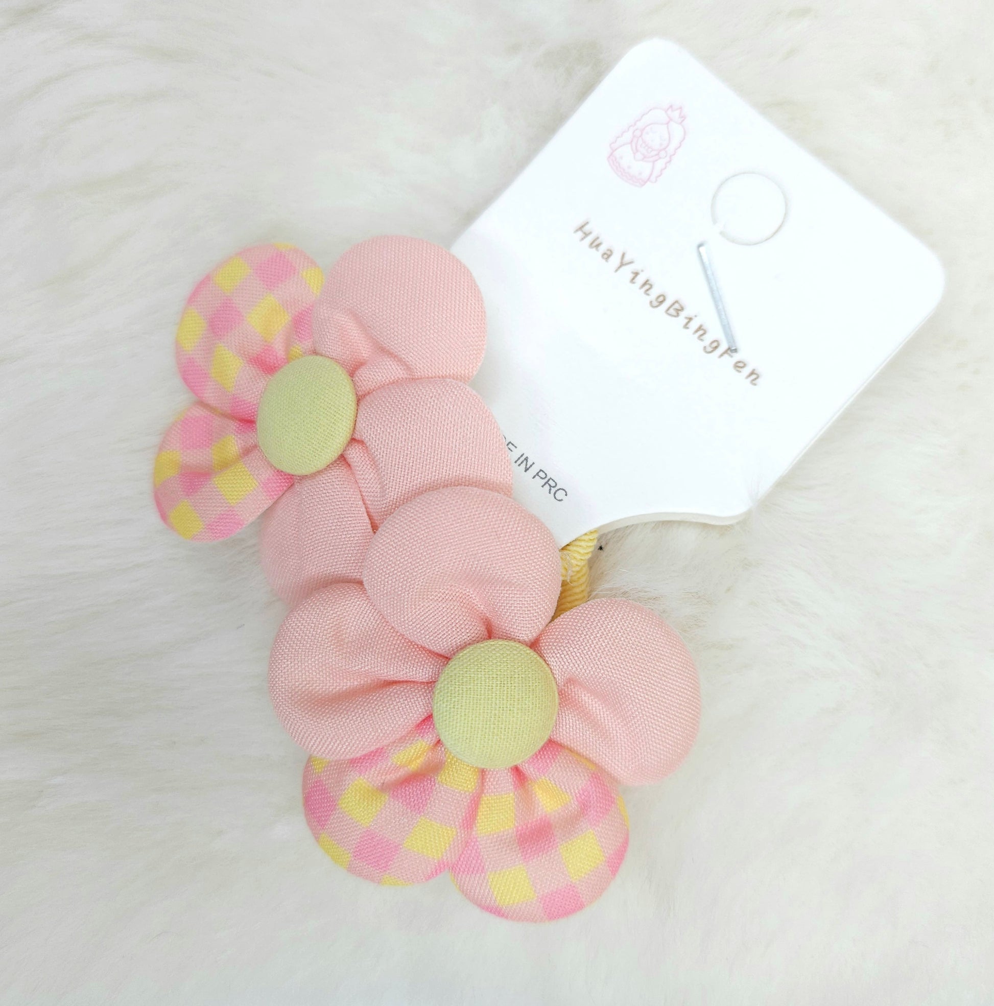 Pink flower-shaped hair ties with checkered patterns on a white background