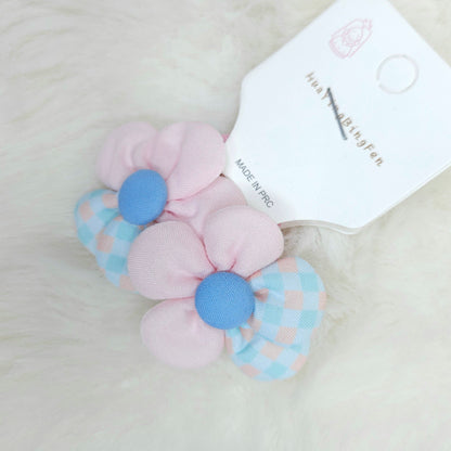 Pastel-colored hair ties with a brand label on a light background