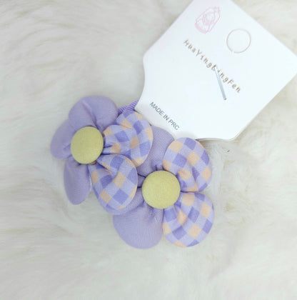Purple checkered hair clip with yellow centers on a white background