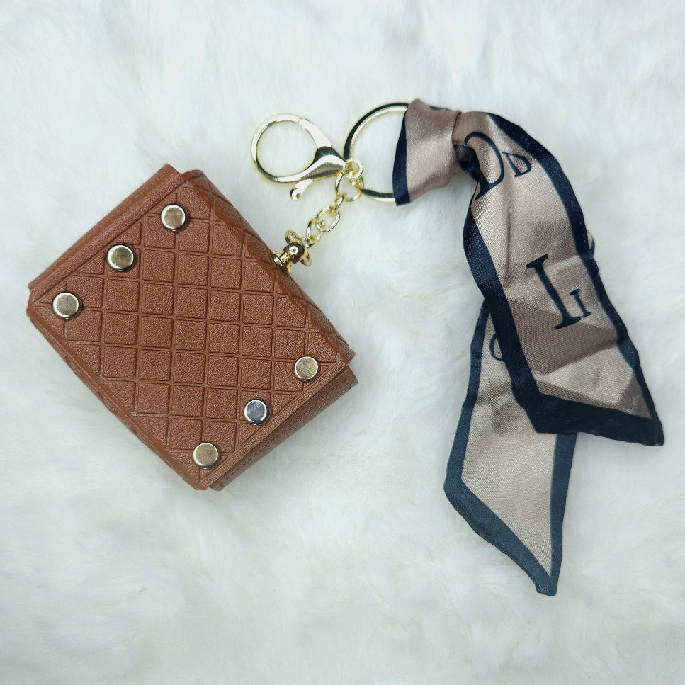 Back view of Brown Quilted Mini Wallet Keychain with gold hardware and a silk-like patterned scarf accent, featuring a decorative bow and flower charm.