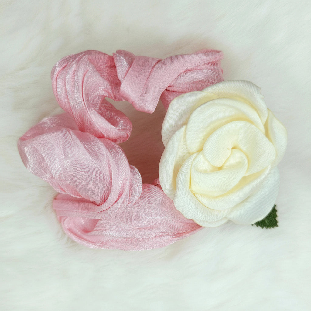 Pink scrunchie and white rose on a white background