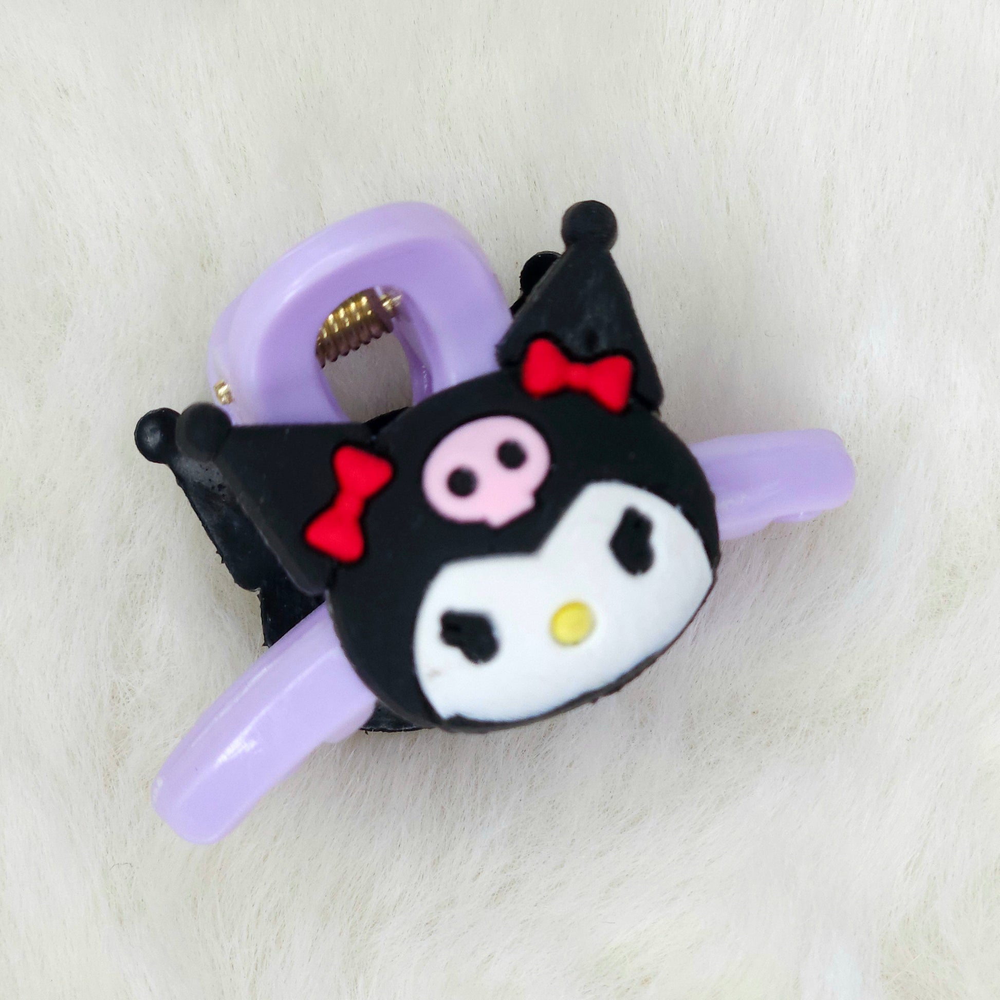 Black cat-shaped hair clip with purple barrette on a white background