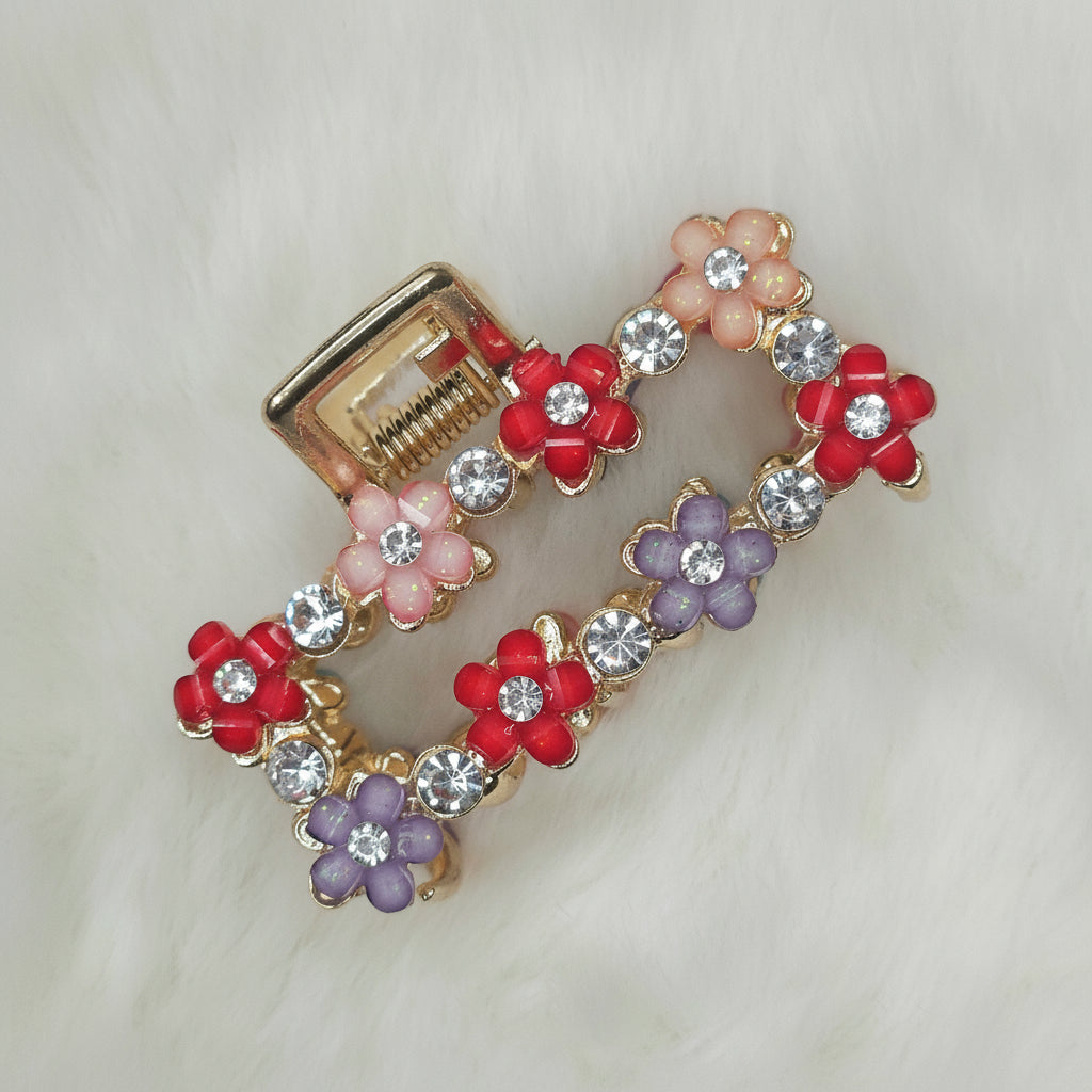 Decorative hair clip with floral designs and rhinestones on a light background