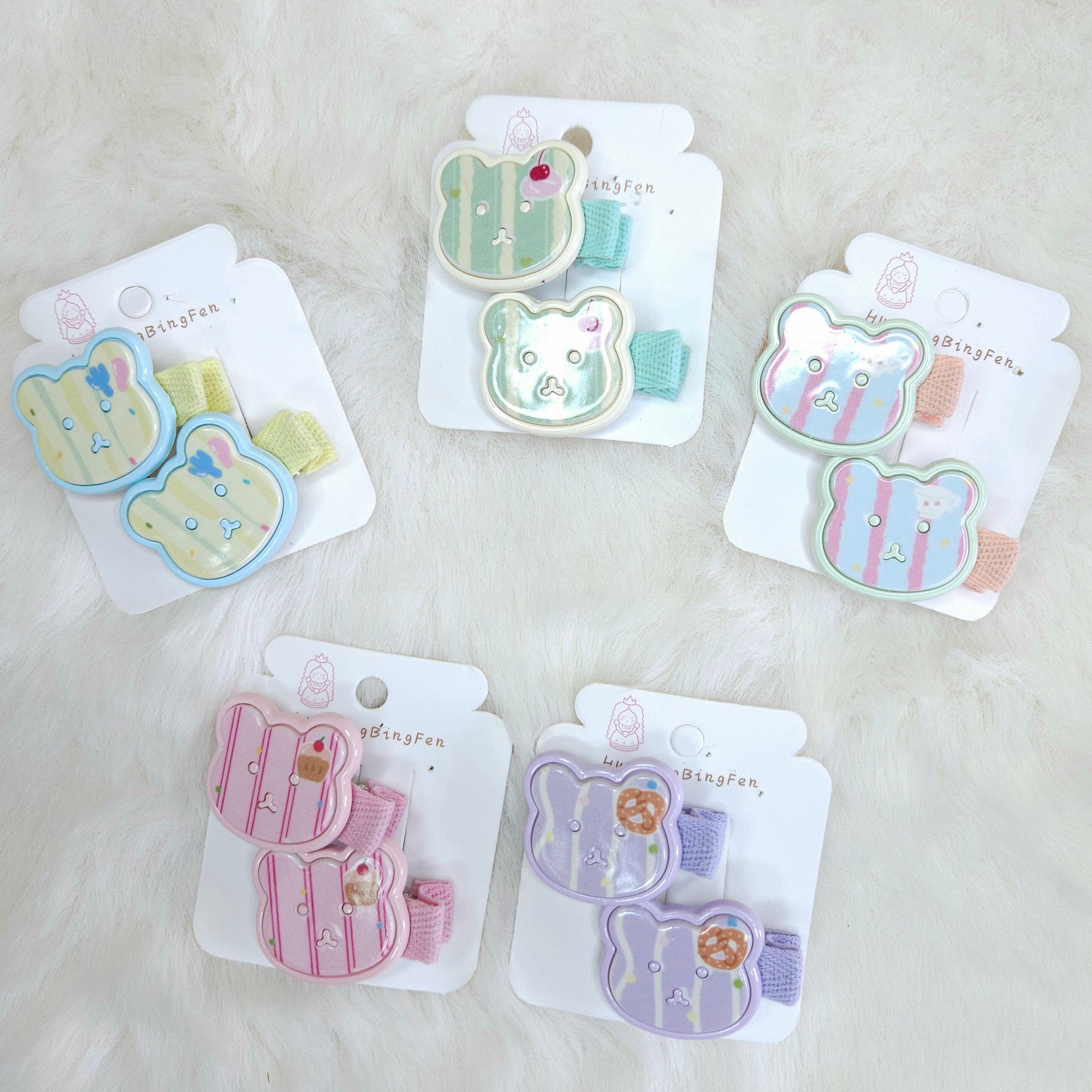Set of five hair clips with cute designs on white packaging against a white background