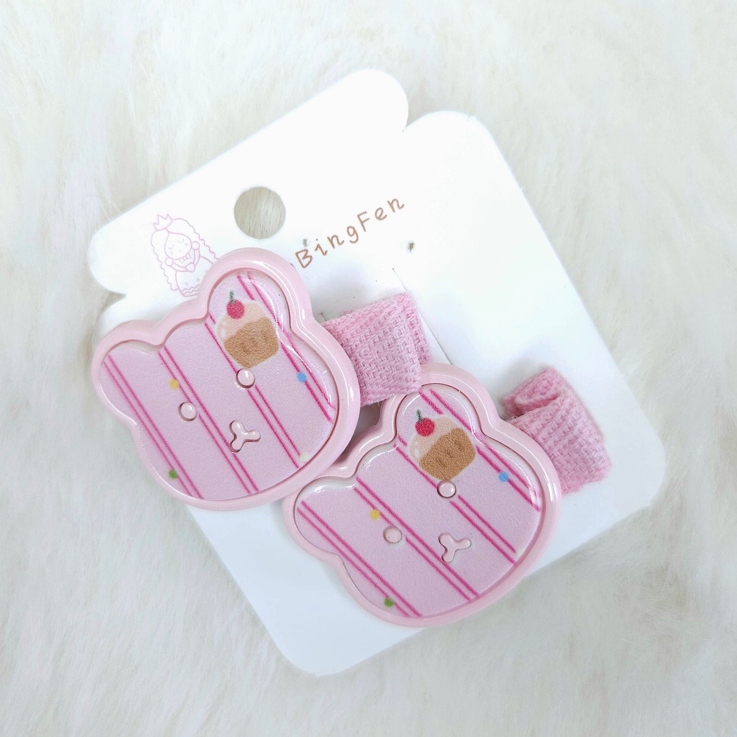 Pink hair clips with cupcake design on a white card with 'BingFan' branding, on a light pink background.