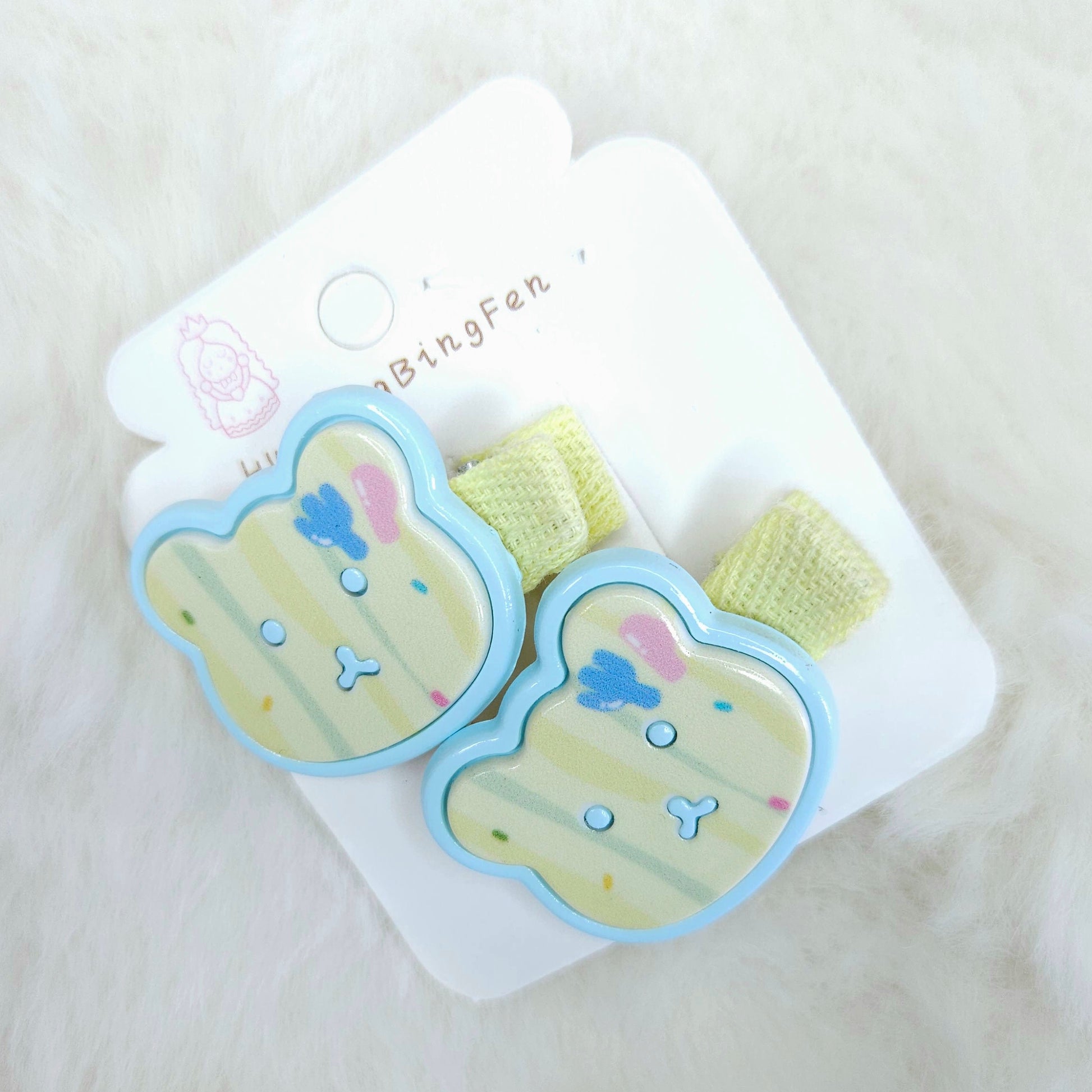 Pair of cartoon-themed hair clips on a white card with a soft white background