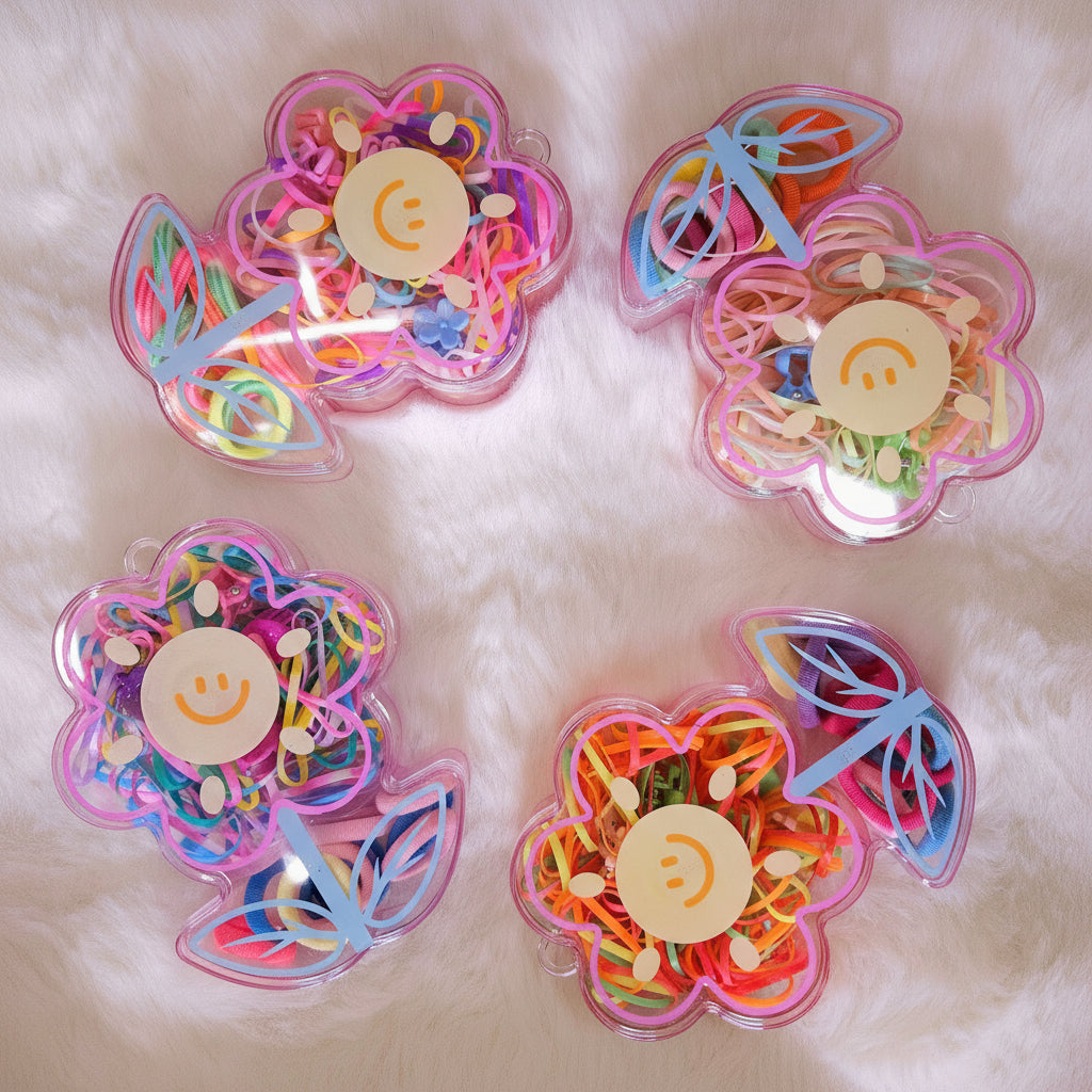 Four transparent containers filled with colorful rubber bands on a white fluffy background
