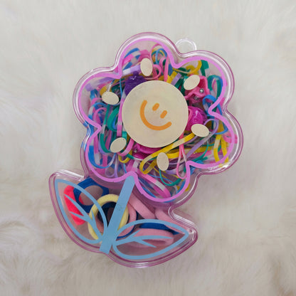 Colorful hair elastic set in a transparent container with a smiley face design on a white background