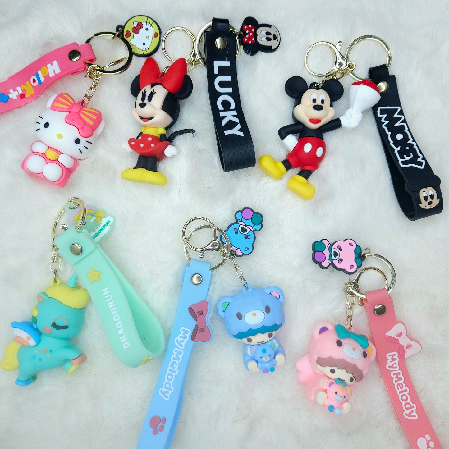 Collection of colorful keychains with cartoon characters on a light gray background