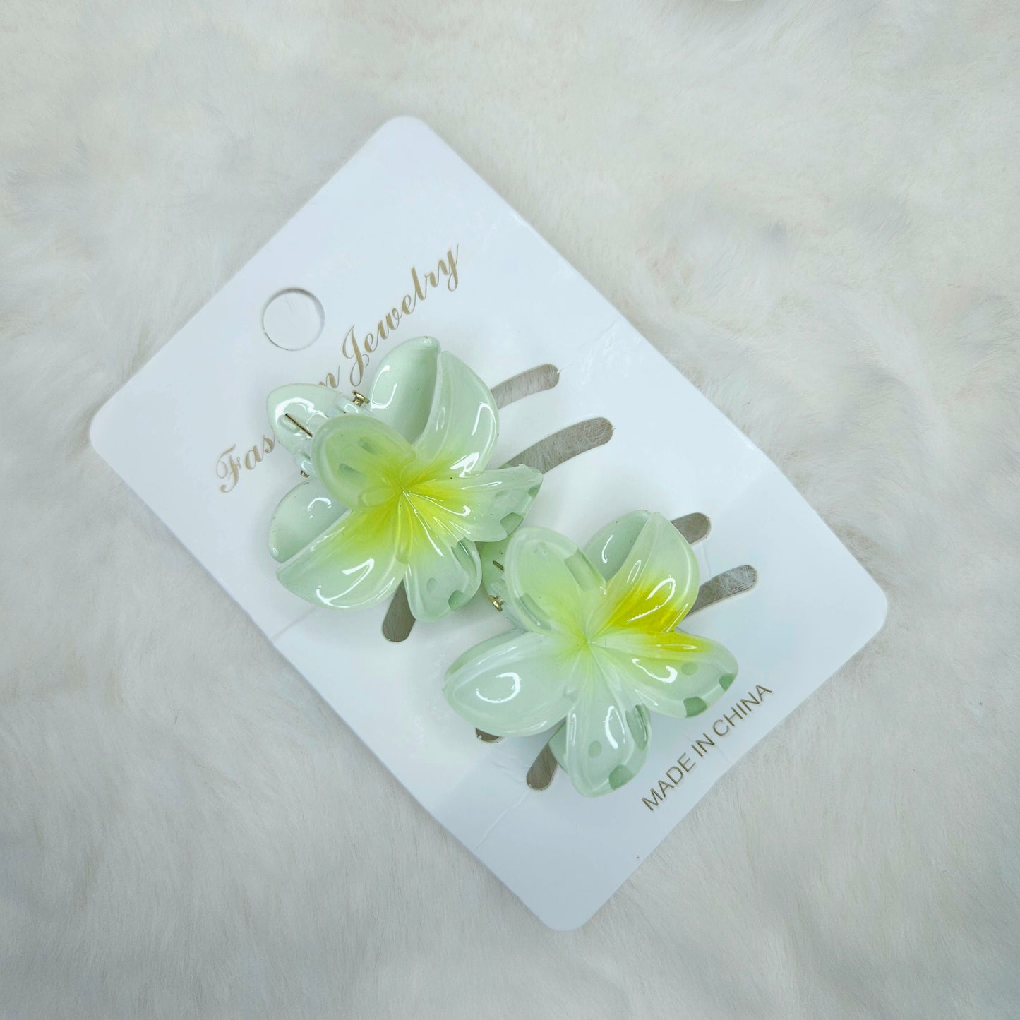 Flower-shaped hair clips on a branded card with 'Made in China' text.