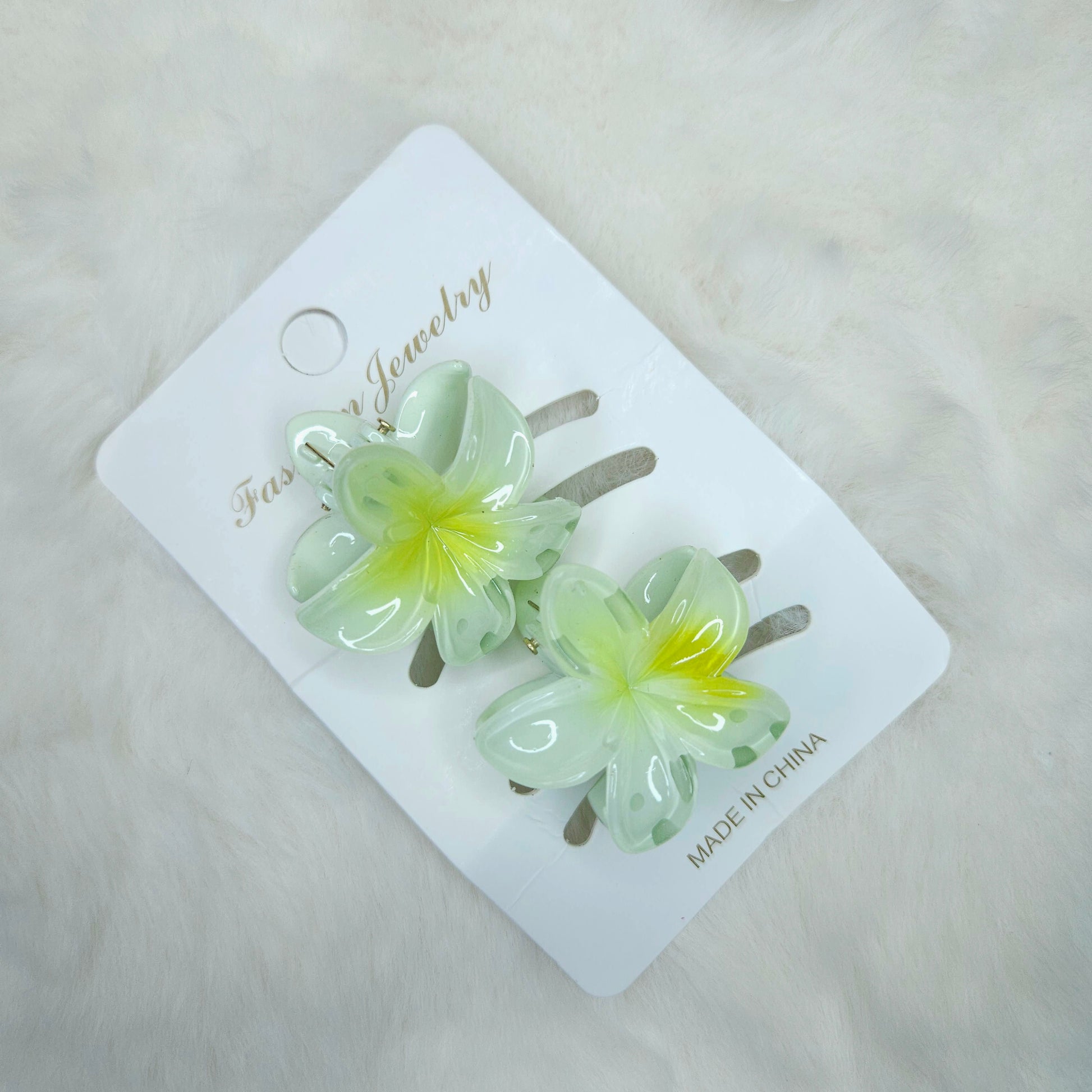 Flower-shaped hair clips on a branded card with 'Made in China' text.