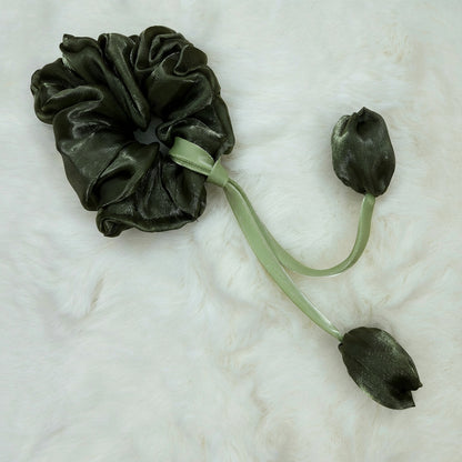 Green organza scrunchie featuring tulip-shaped fabric ends and soft green ribbon detailing.