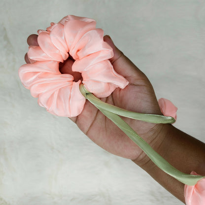 Soft rose hair scrunchie styled with tulip-shaped fabric flowers on green stems.