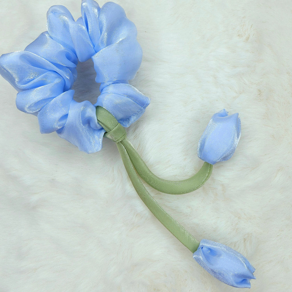 Floral-inspired purple scrunchie with tulip decorations and green stem-like ribbons.