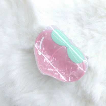 Pink and green hair claw in clear packaging on a white fur background