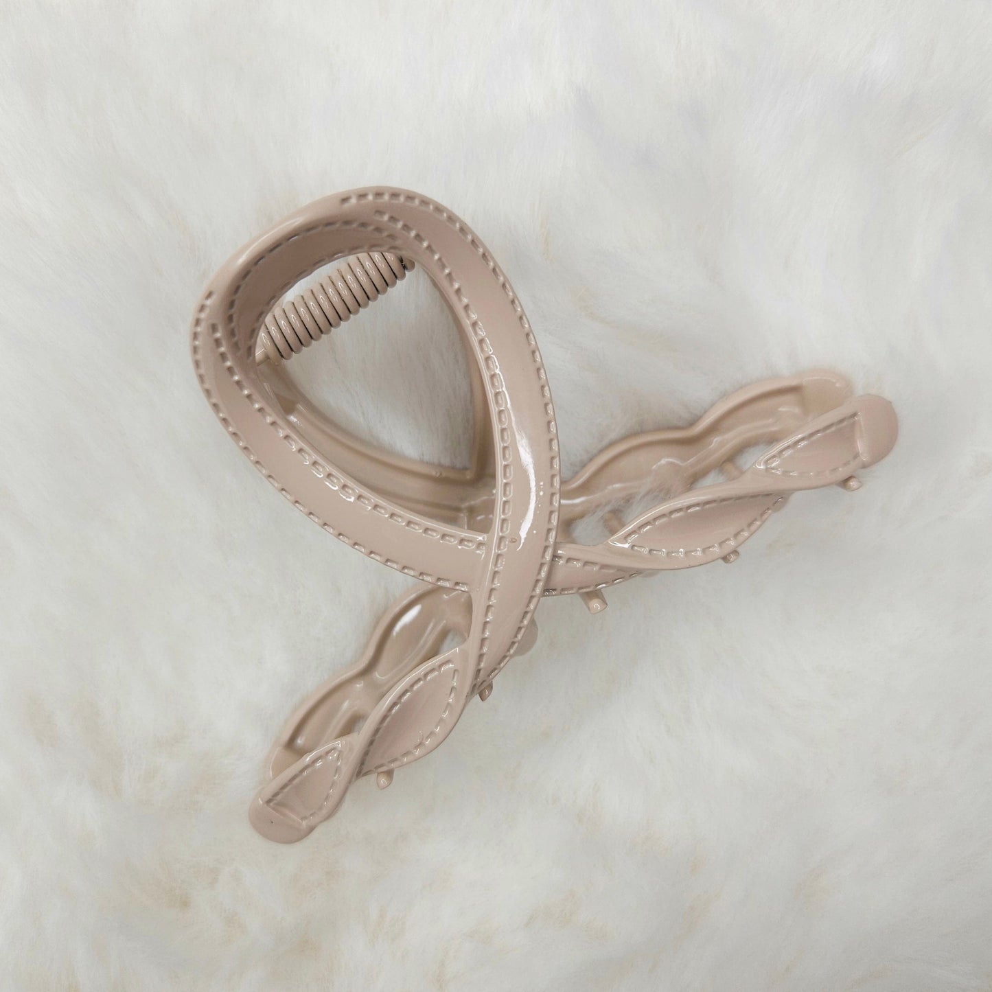 Beige hair clip on a light marble background