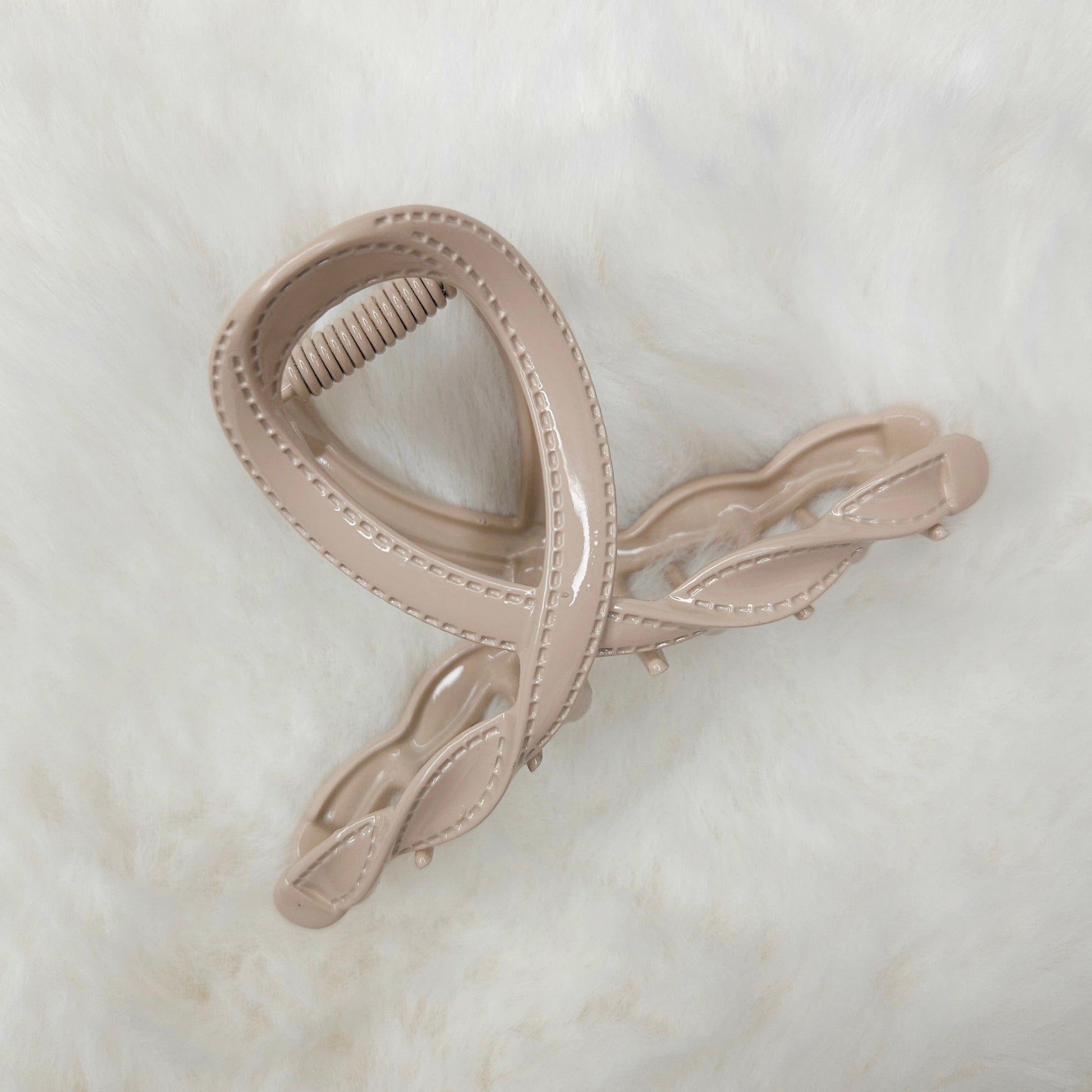 Beige hair clip on a light marble background