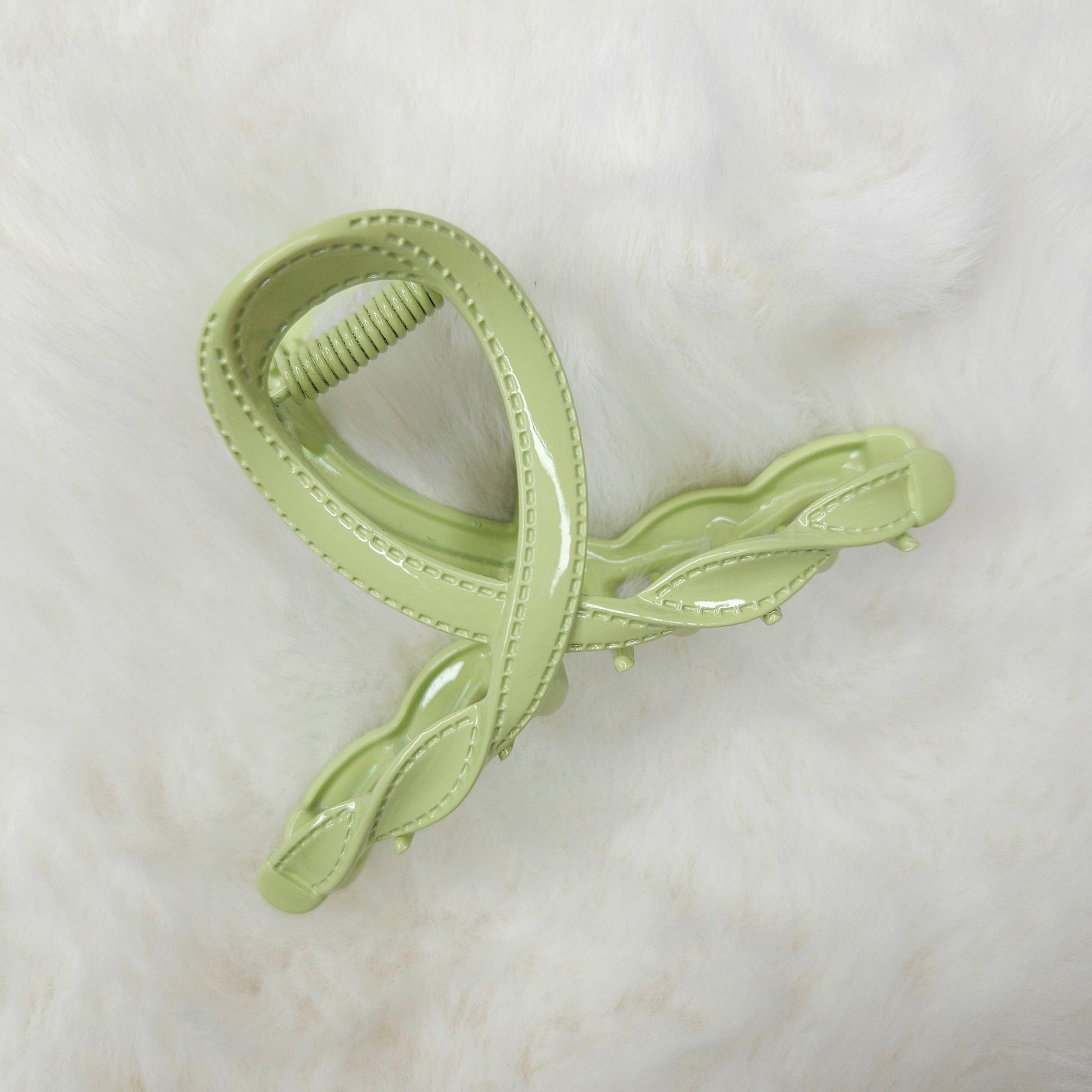 Light green hair clip with leaf design on a white background