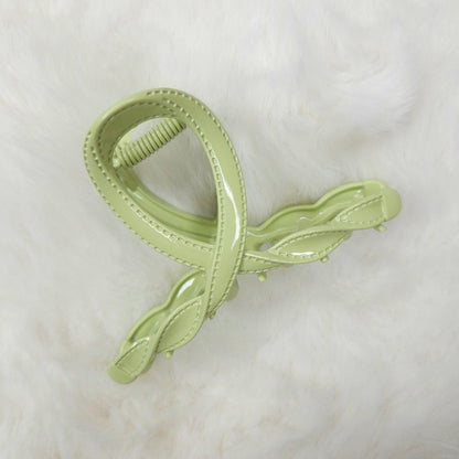 Light green hair clip with leaf design on a white background