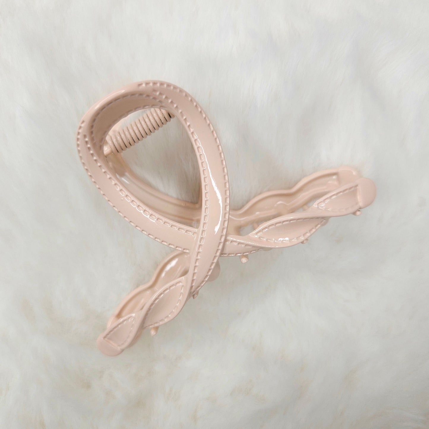 Pink hair clip on a light marble background