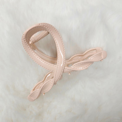 Pink hair clip on a light marble background