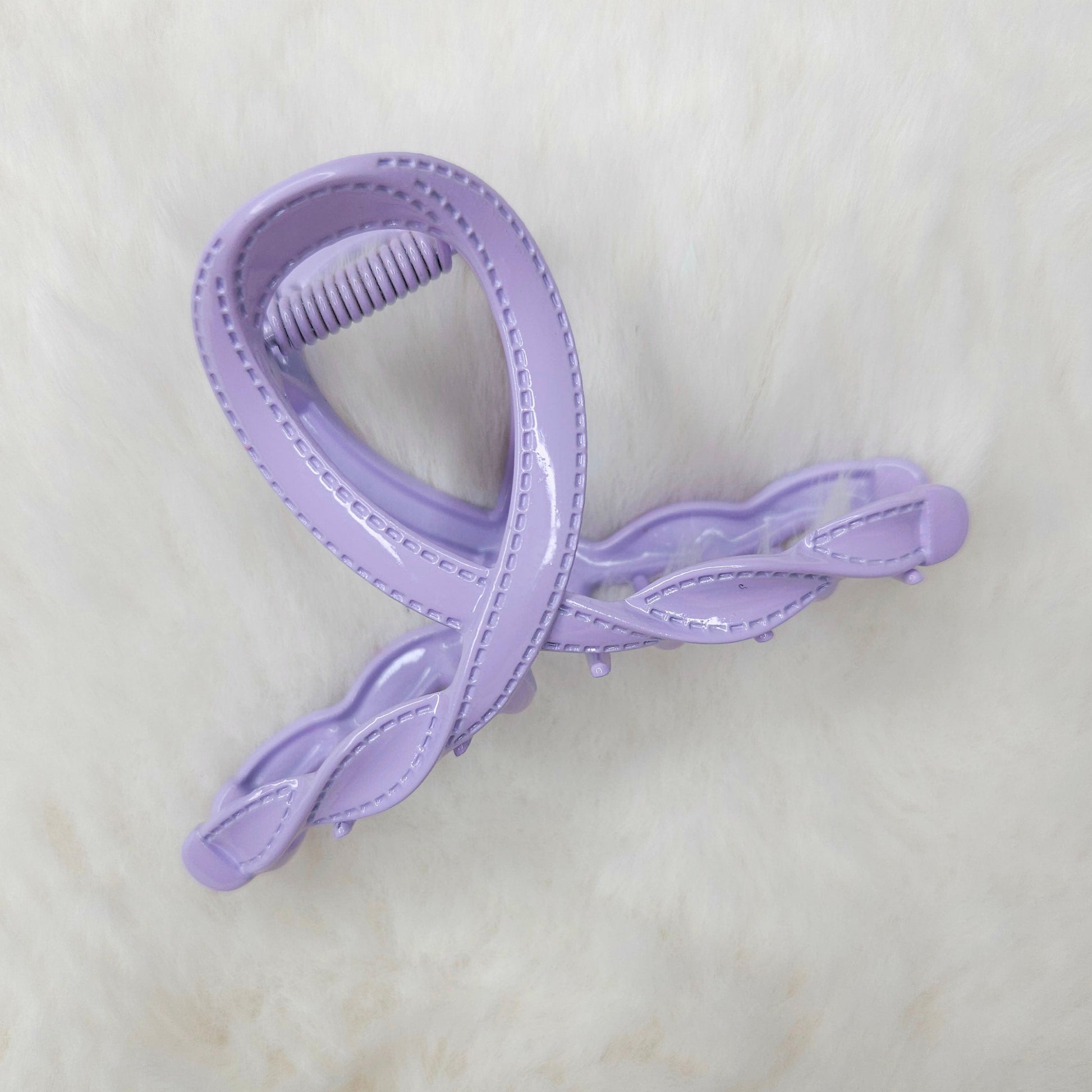 Purple hair clip on a light beige background