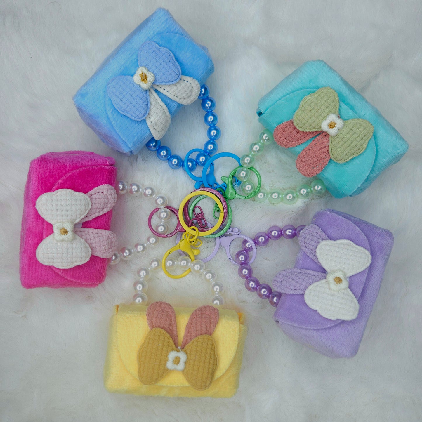 Set of colorful keychains with bow designs on a light gray background