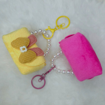Yellow and pink keychain with a pearl chain on a light gray background