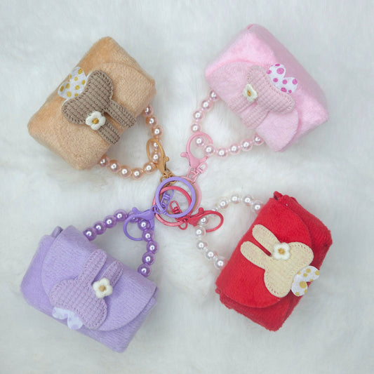 Set of four small fabric bags with decorative elements on a white background